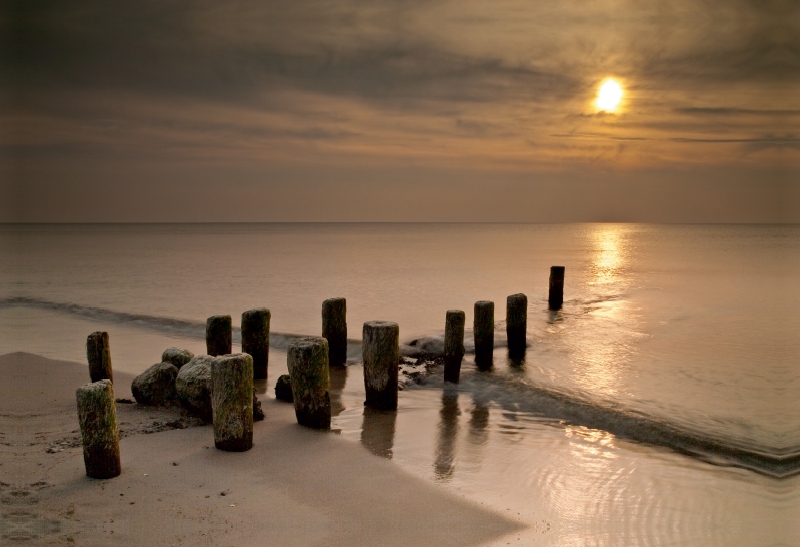 Buhnen an der Ostseeküste mit Sonnenuntergang