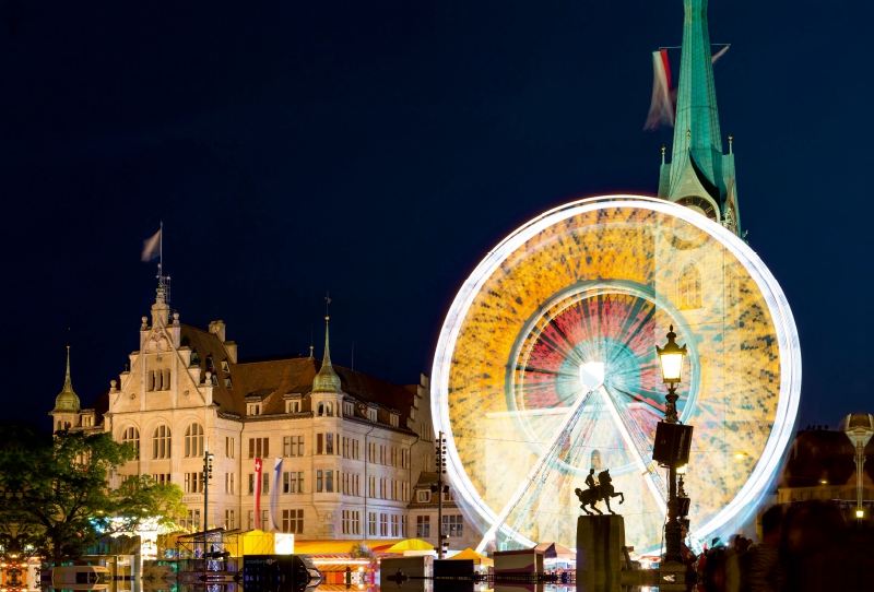 Riesenrad vor historischer Kulisse.