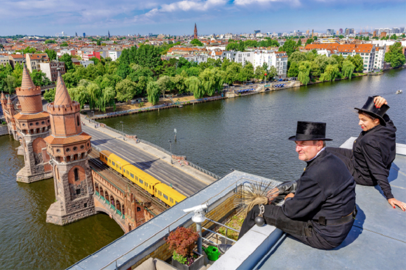 Schornsteinfeger über der Spree und Oberbaumbrücke in Berlin