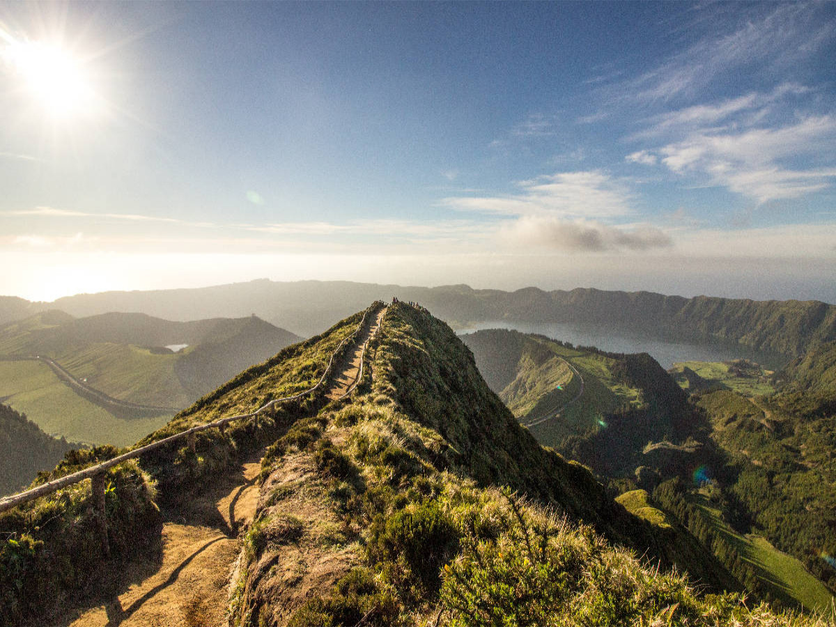 Traumhaftes Landschaftsbild mit Blick auf einen See innerhalb eines Vulkankraters der Azoreninsel São Miguel und im Hintergrund das Meer