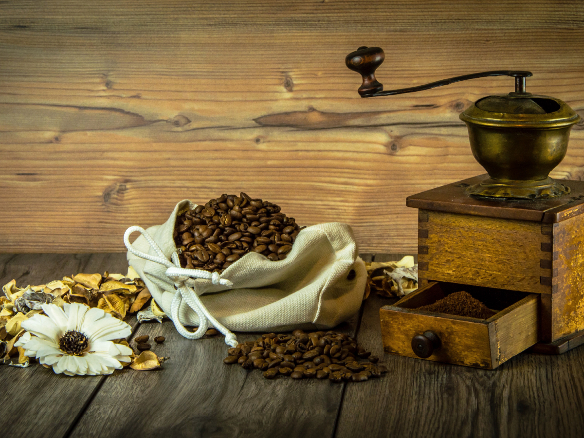 Kaffeemühle mit Kaffeebohnen und Blumen