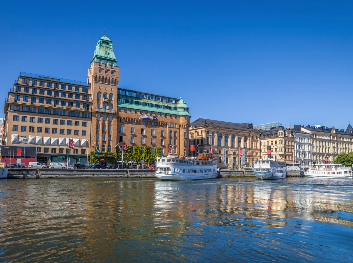 Hafen von Stockholm mit historischem Hotel und Fährschiffen