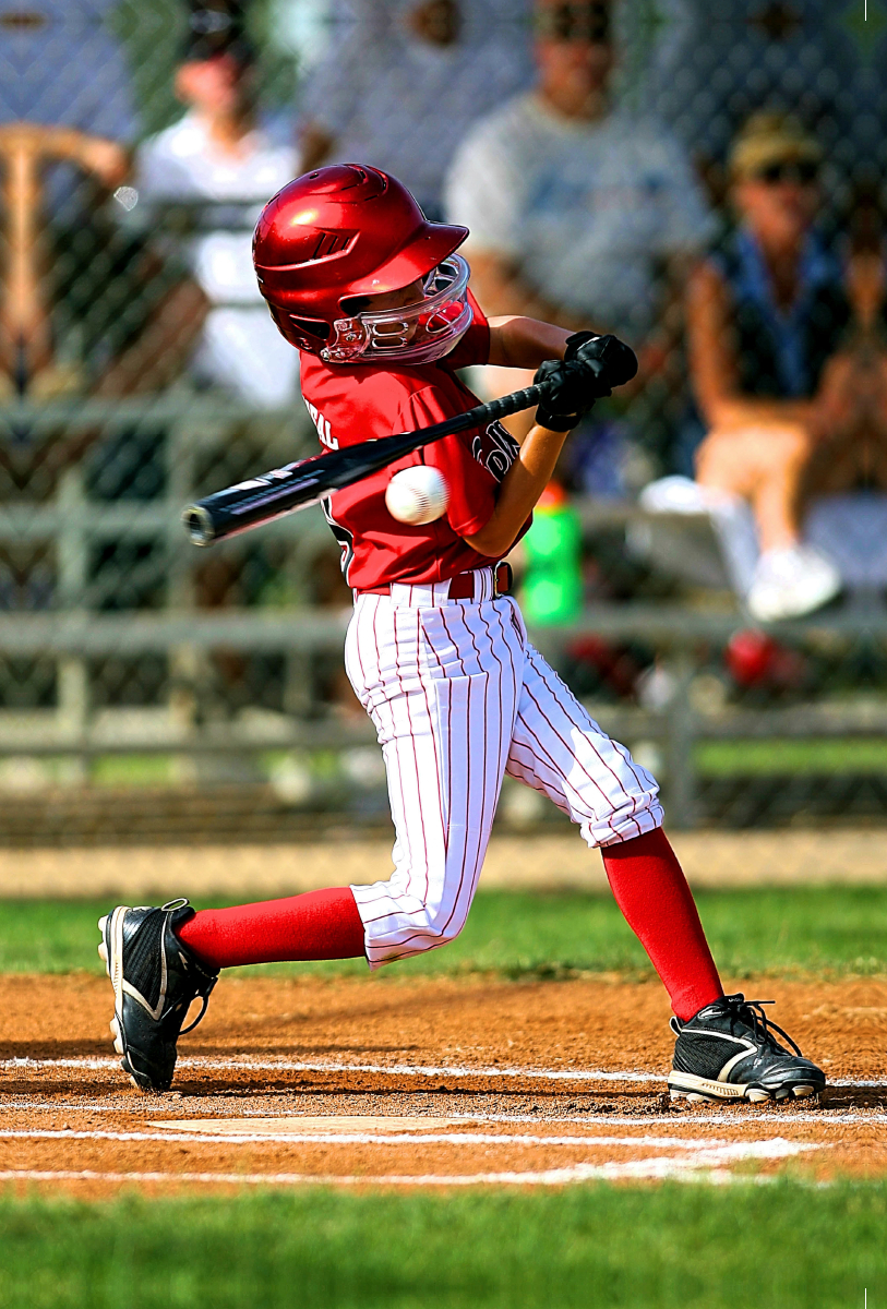 Baseball - kleiner Batter schlägt den Ball