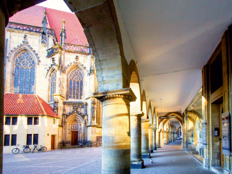 Münster - Die typischen Rundbögen am Lambertikirch-Platz, Blick auf Lambertikirche