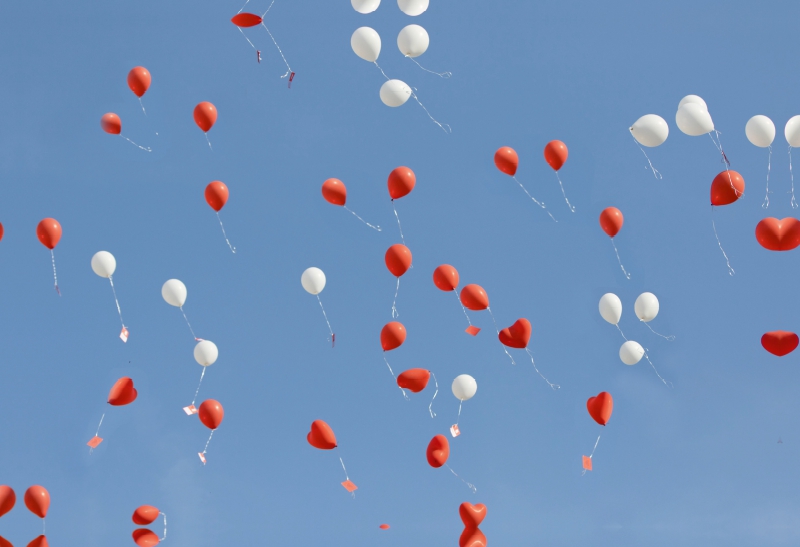 Luftballons mit lieben Wünschen steigen in den Himmel