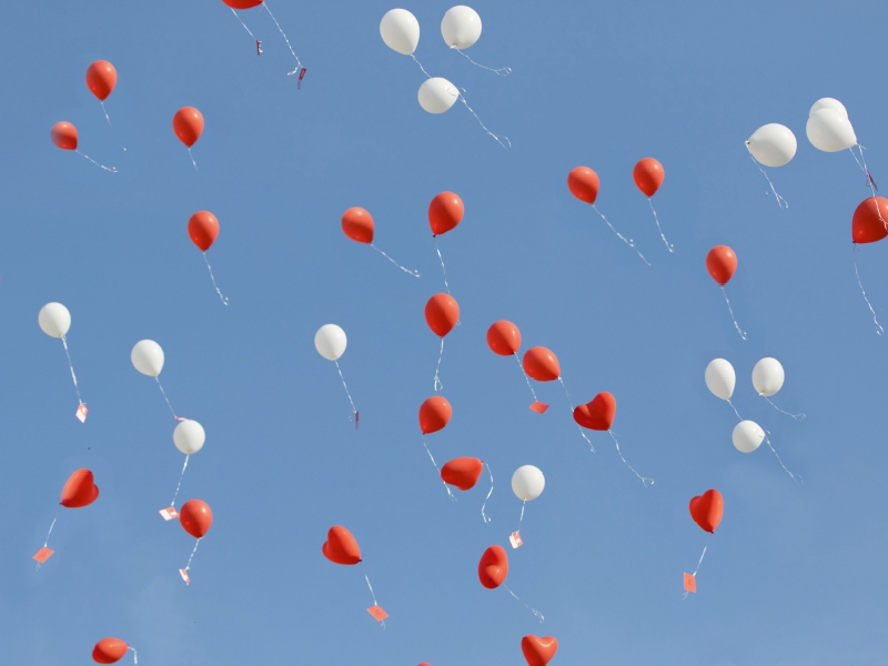 Luftballons mit lieben Wünschen steigen in den Himmel