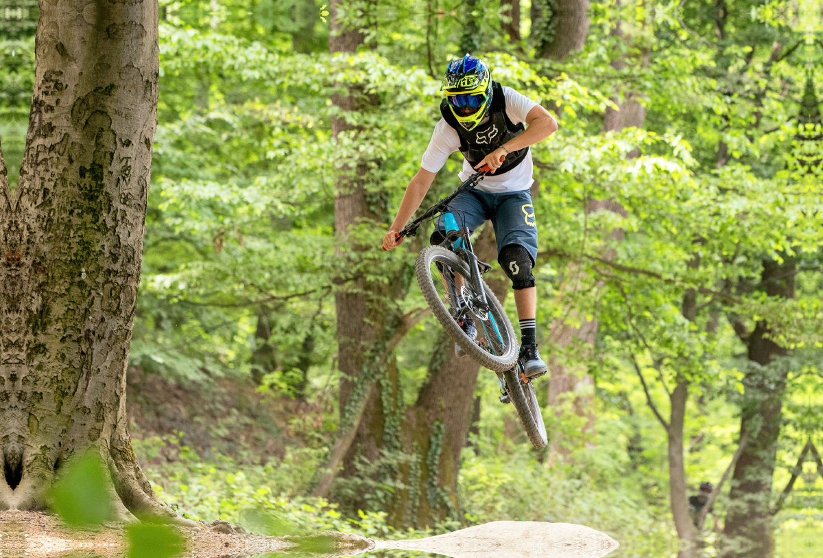 Ambitionierter Mountain Biker während eines Sprungs.