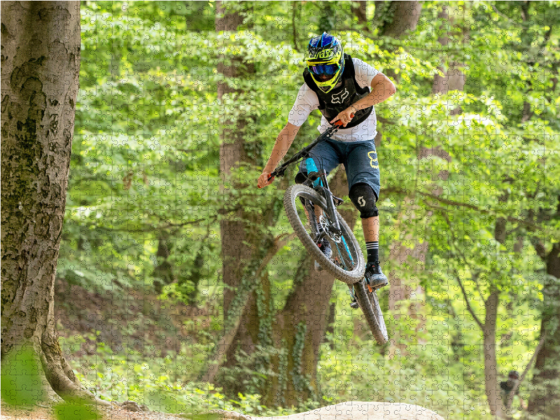 Ambitionierter Mountain Biker während eines Sprungs.