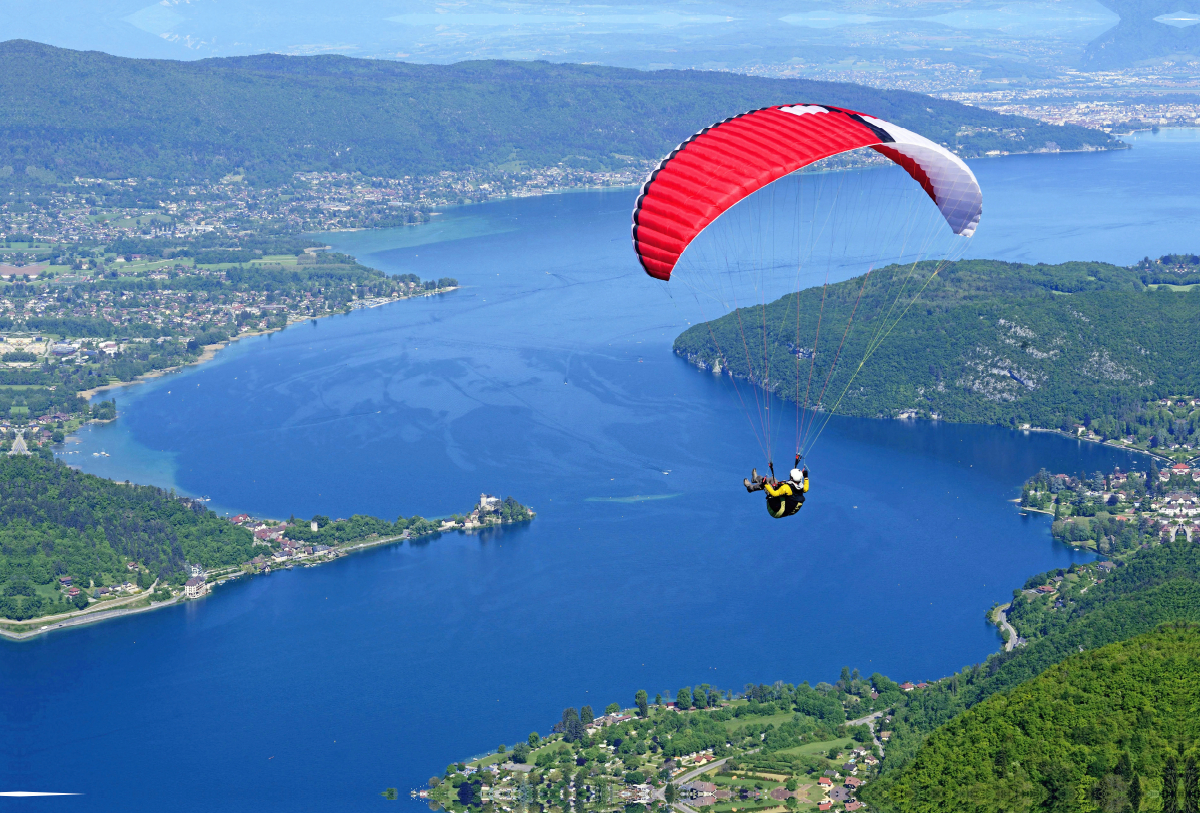 Paragleiter über dem See Lac d'Annecy.