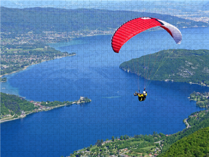 Paragleiter über dem See Lac d'Annecy.