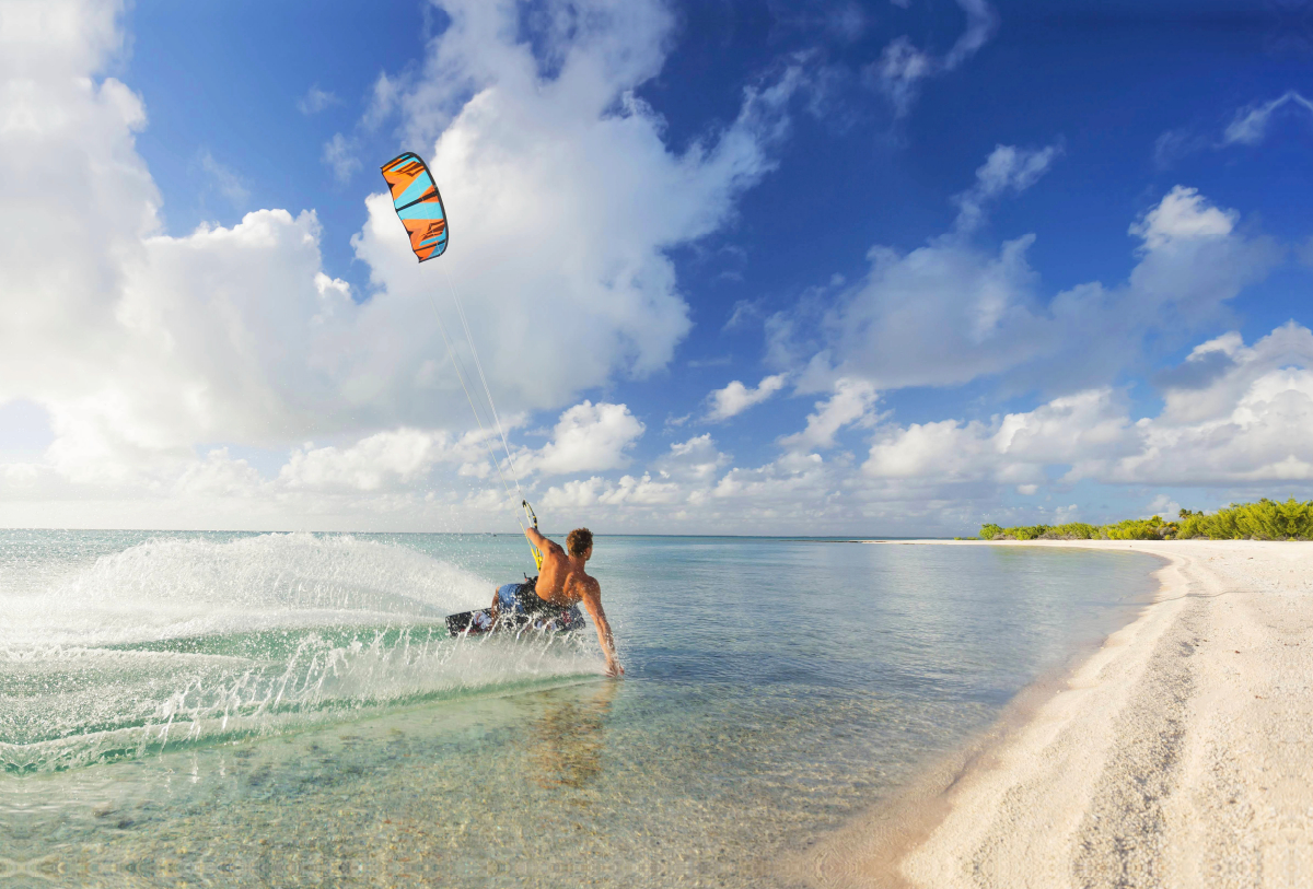 Athletischer Kiteboarder in einer tropischen Lagune.