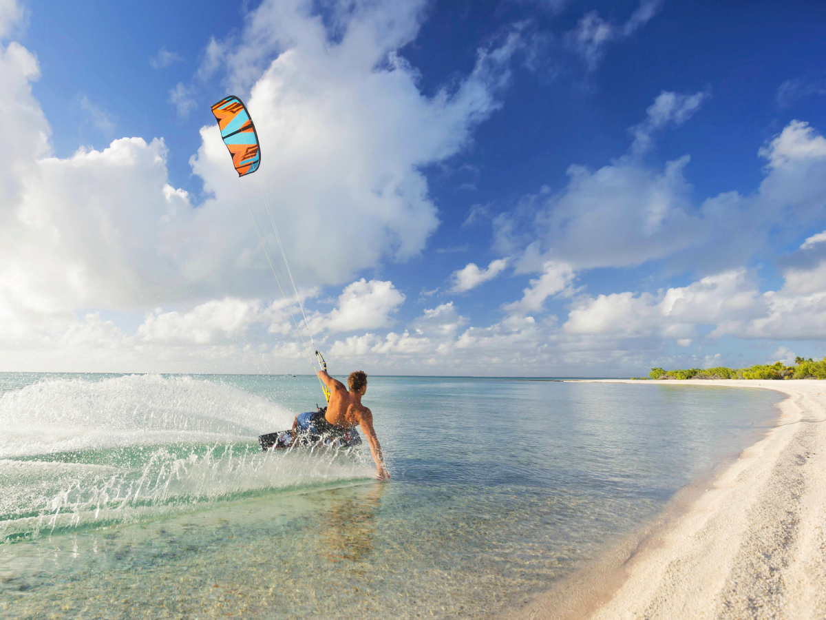 Athletischer Kiteboarder in einer tropischen Lagune.