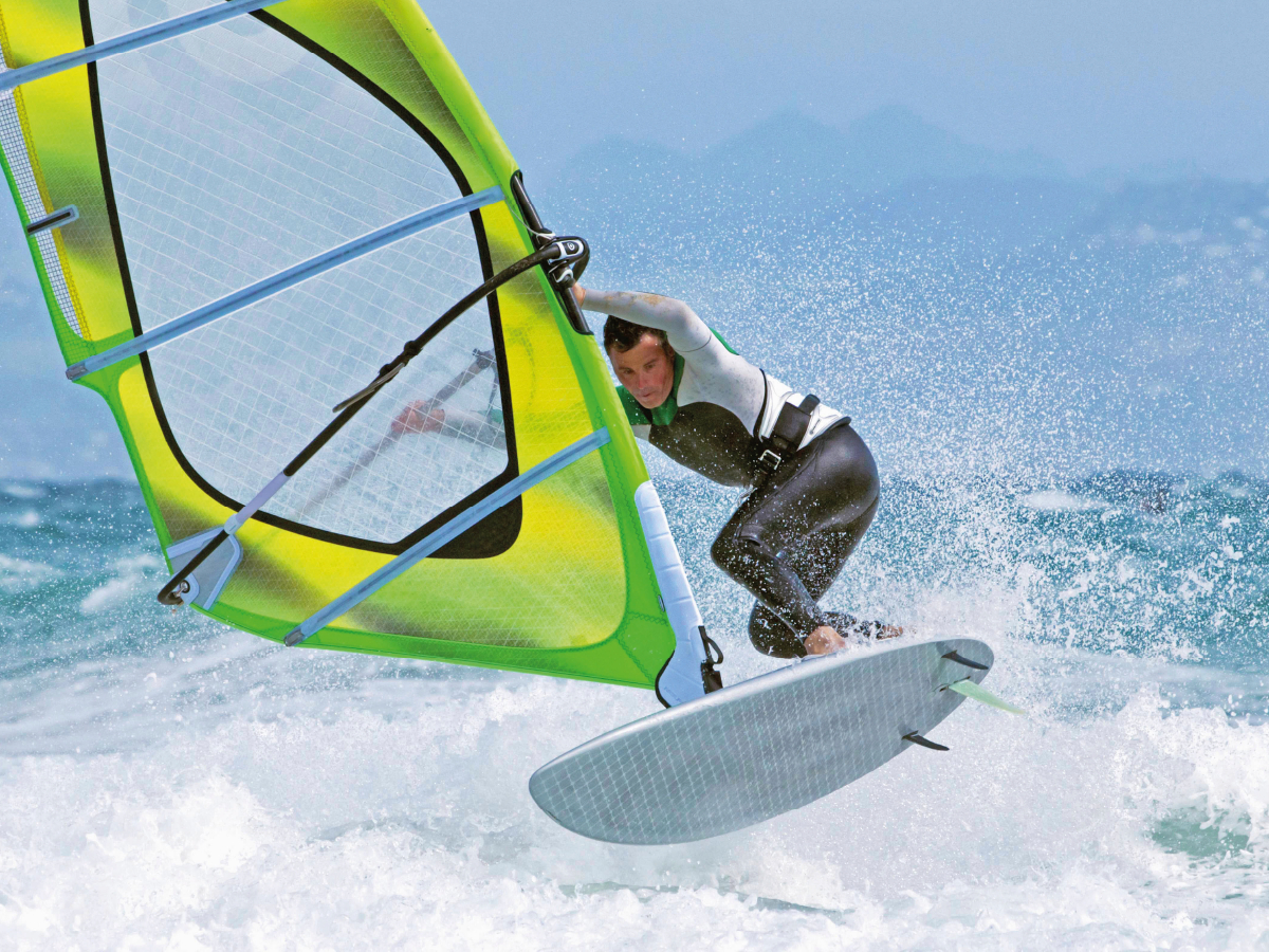 Die Magie von Wind und Wellen erleben - ein Windsurfer mitten in der Gischt.