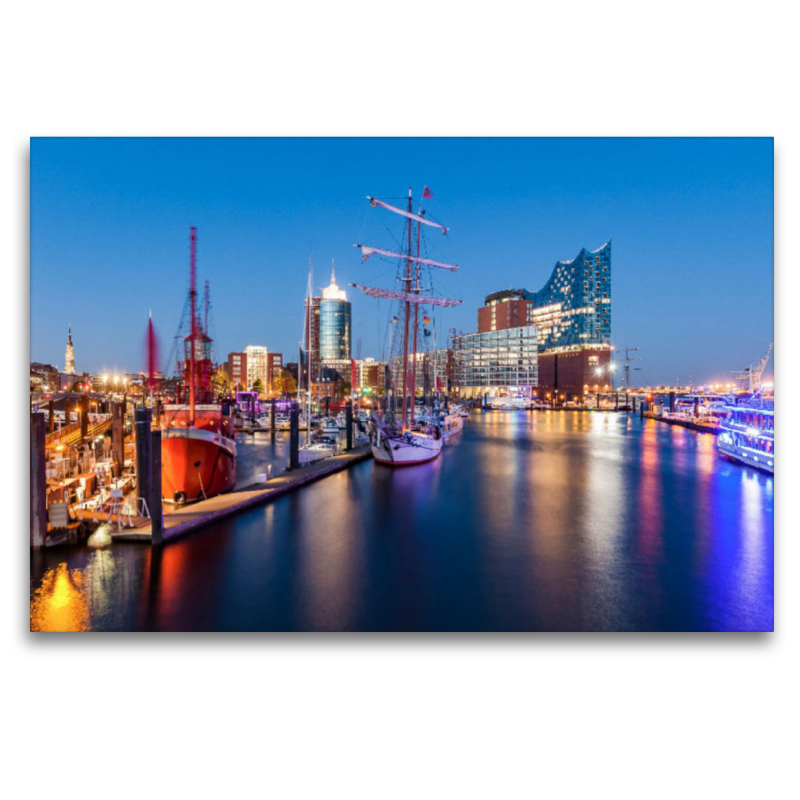 Ausflugsboote und die Elbphilharmonie in der HafenCity in Hamburg bei Nacht.