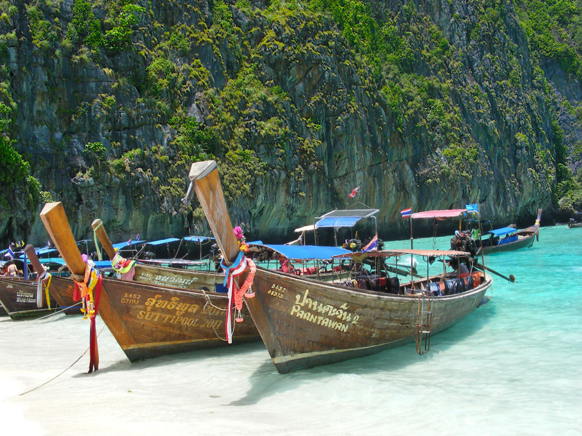 Longtailboote am Strand in Thailand