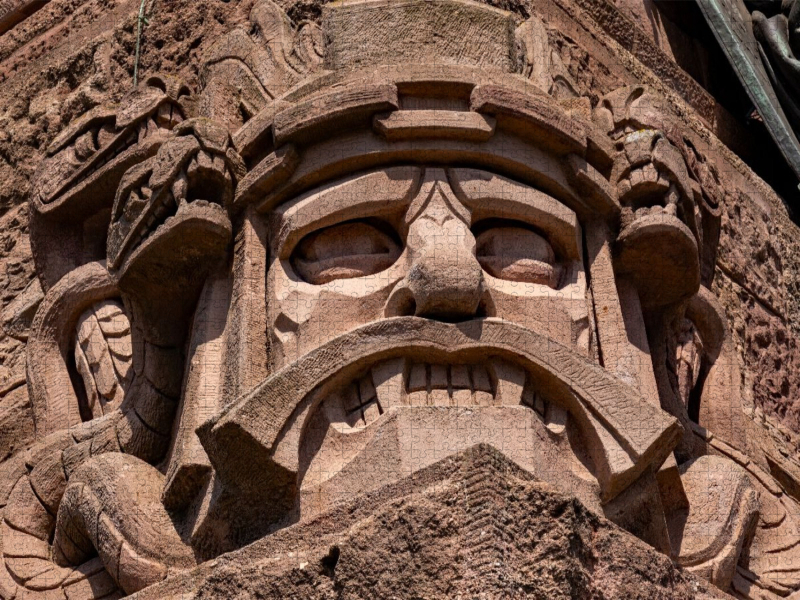 Knurrenden Sandstein Kopfmaske mit Schlangen