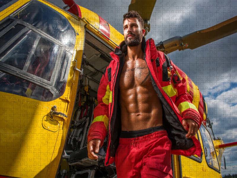 Attraktiver Notarzt mit Sixpack vor Rettungshubschrauber