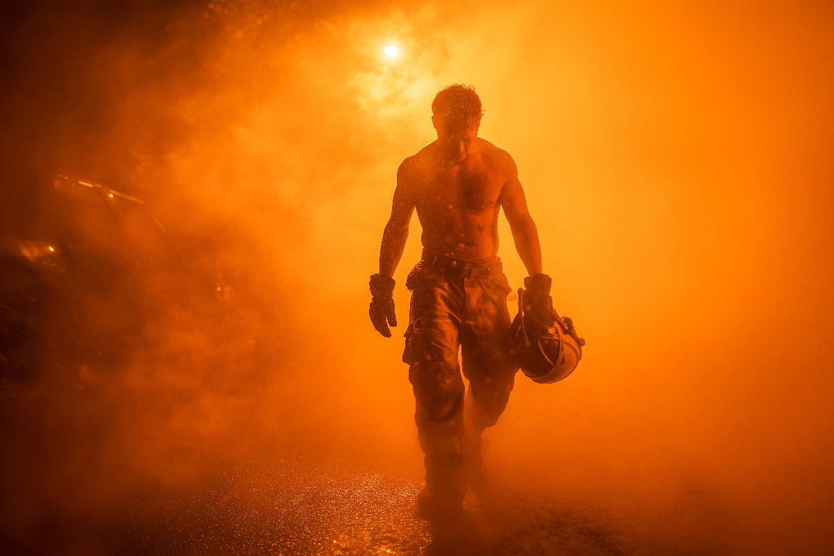 Feuriger und sexy Feuerwehrmann mit Muskeln im Einsatz