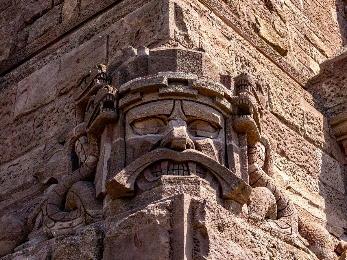 Eine von vier knurrende Sandstein Kopfmasken mit Schlangen