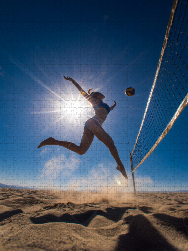 Sexy Volleyballspielerin springt im Sand unter der Sonne