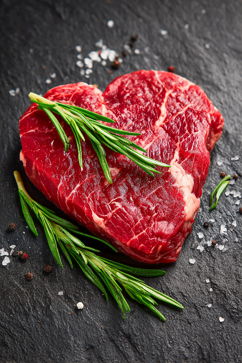 Herzförmiges Steak aus Rindfleisch mit frischem Rosmarin
