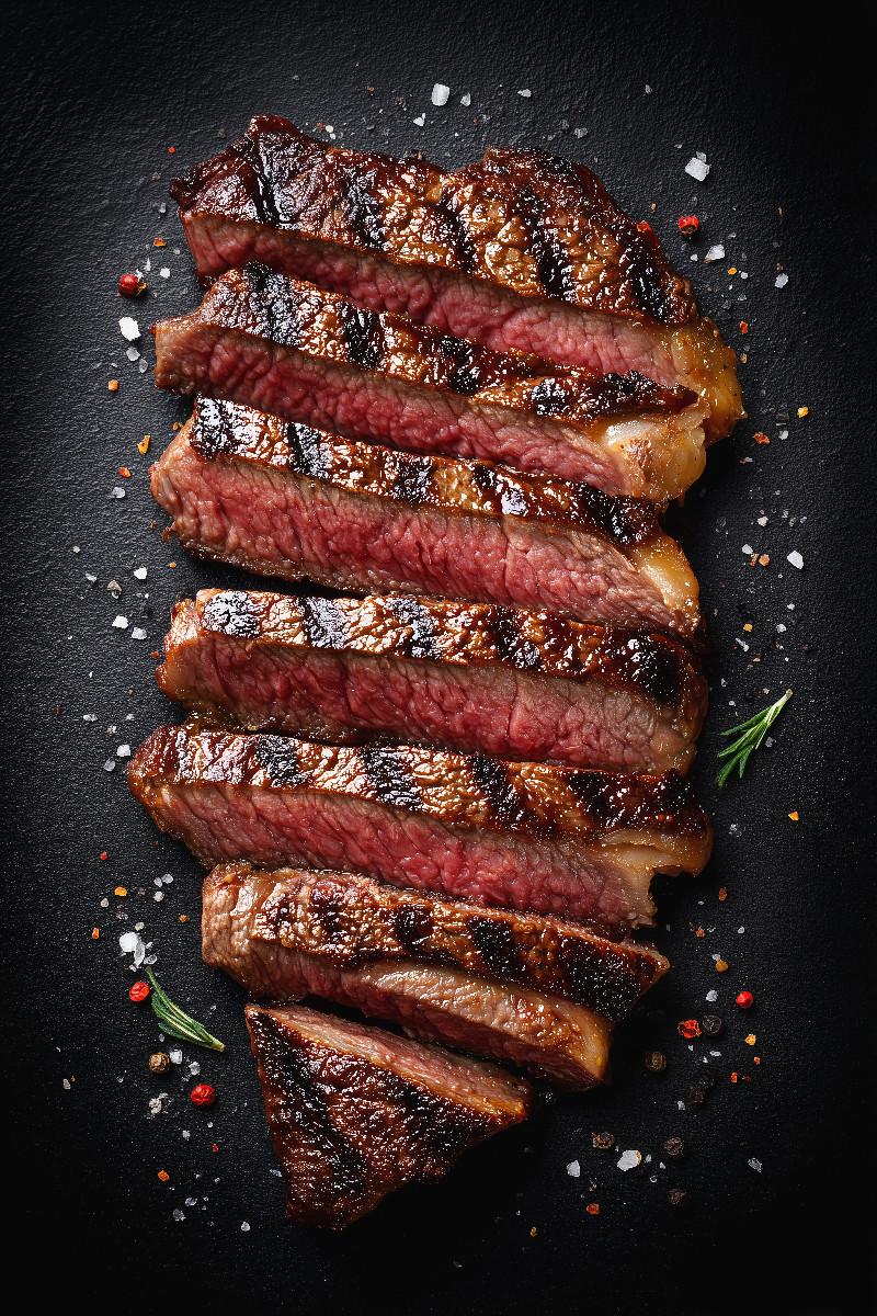 Saftiges Steak in Scheiben mit Grillstreifen und Gewürzen