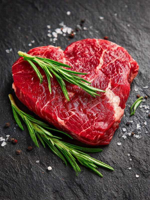 Herzförmiges Steak aus Rindfleisch mit frischem Rosmarin