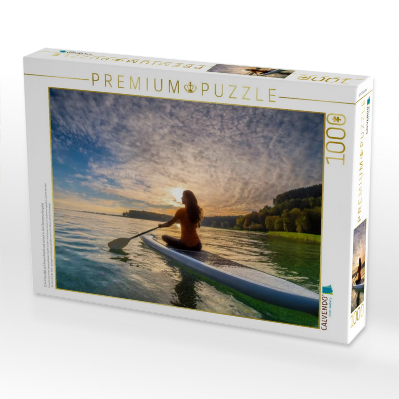 Eine Frau sitzt auf ihrem Board und schaut in den Sonnenuntergang