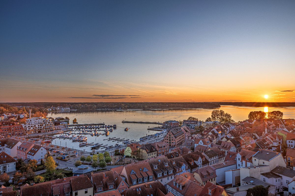 Blick vom Turm der Marienkirche auf die Altstadt, den Stadthafen und die Müritz beim Sonnenuntergang