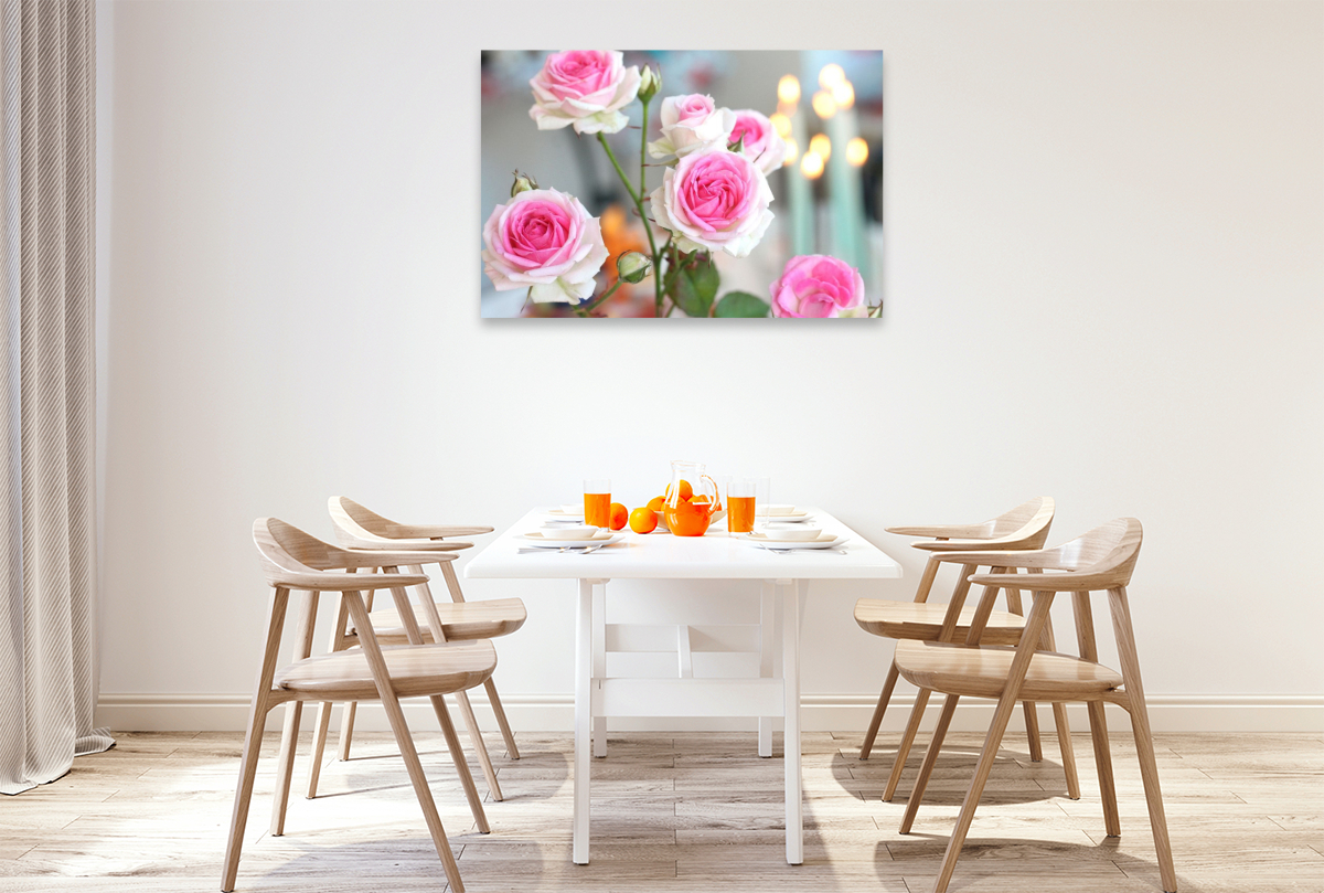 Rosa Rosen mit brennenden Kerzen im Hintergrund