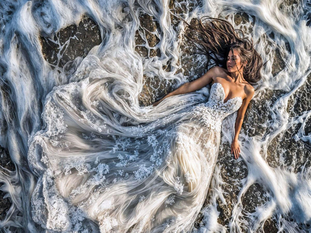 Braut im Brautkleid in Meereswellen