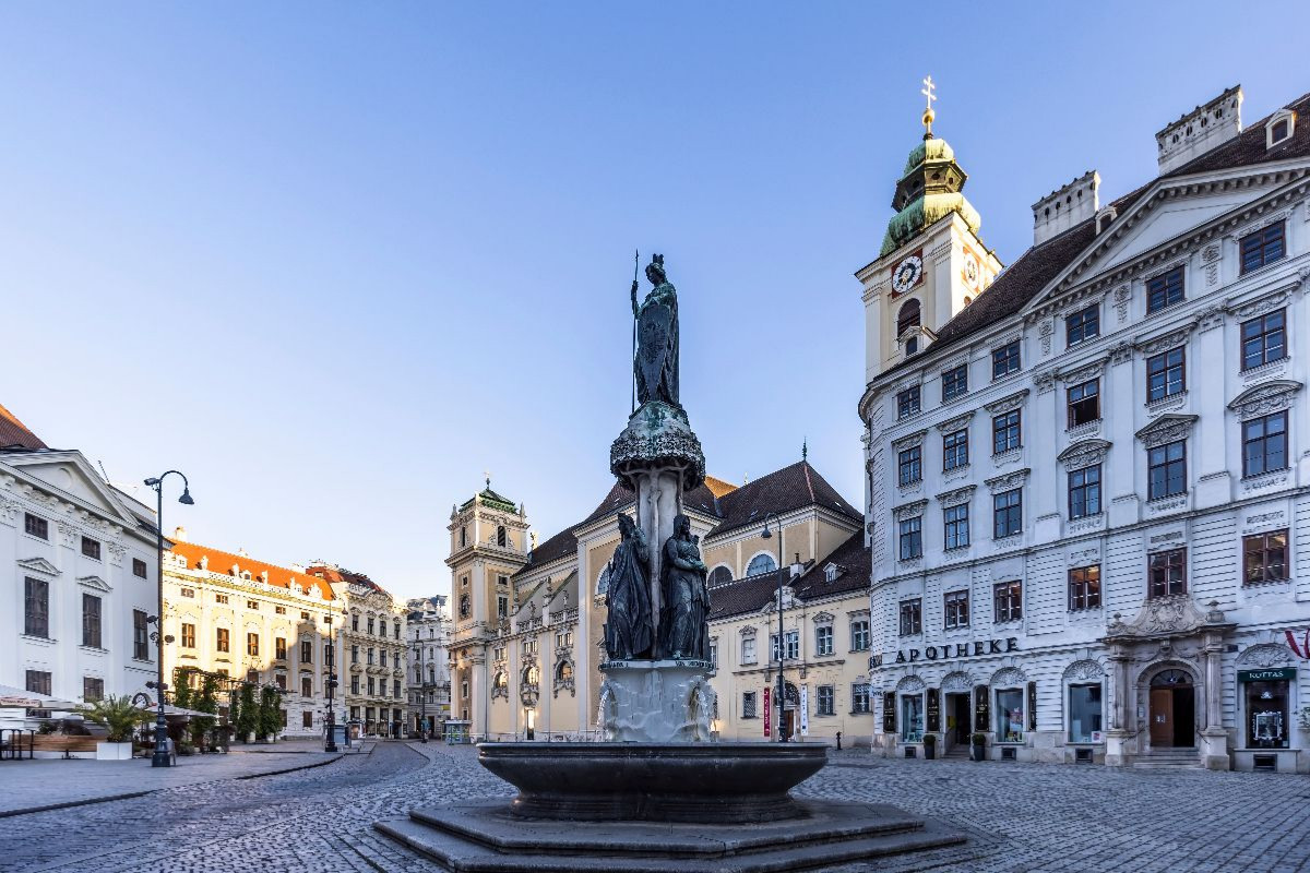 Austriabrunnen und Schottenkirche auf dem Platz Freyung in Wien