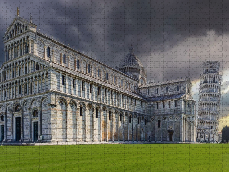 Pisa: Der monumentale Dom Santa Maria Assunta und der weltberühmte Schiefe Turm auf dem leuchtend grünen Rasen der Piazza dei Miracoli.
