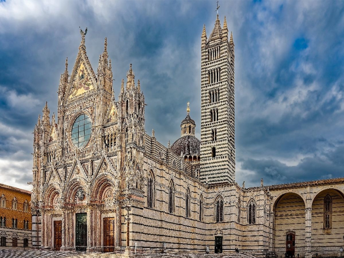 Siena: Die prachtvolle gotische Fassade des Doms Santa Maria Assunta und der charakteristisch gestreifte Glockenturm.