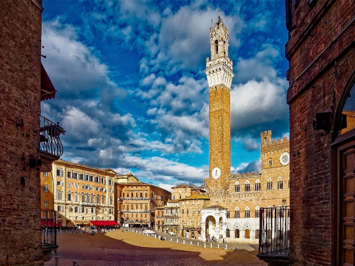 Siena: Der imposante Torre del Mangia an der Piazza del Campo, eingerahmt von historischen Mauern.