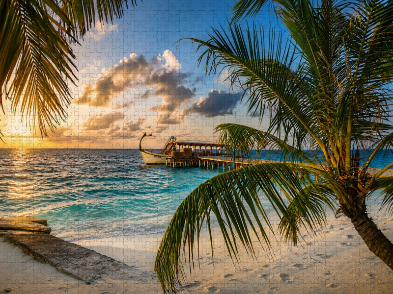 Sonnenuntergang am Malediven-Strand mit traditionellem Dhoni-Boot und Palmen