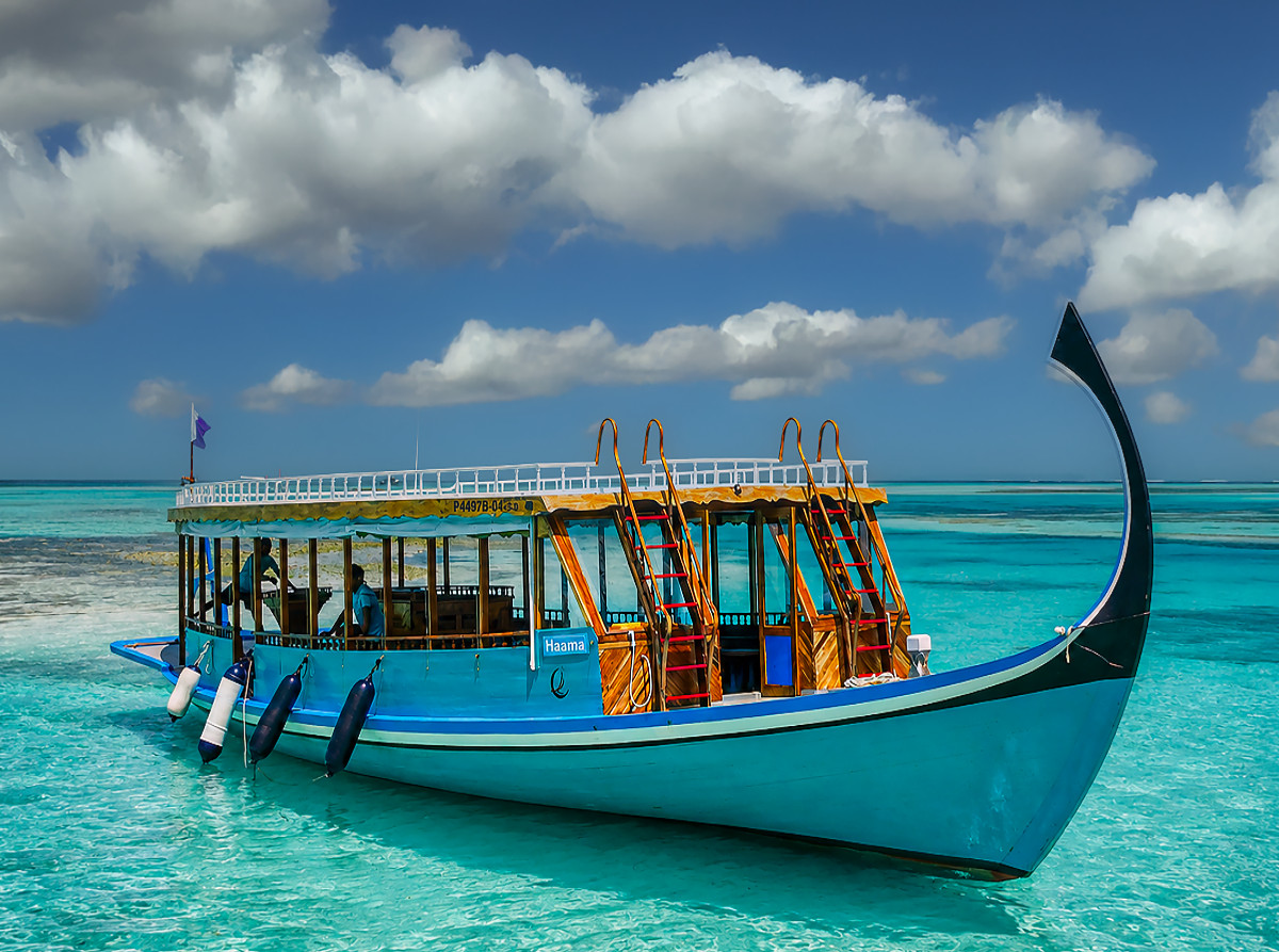 Traditionelles Dhoni-Boot auf türkisblauem Meer der Malediven