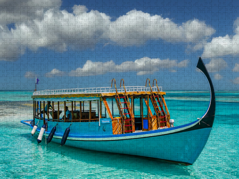 Traditionelles Dhoni-Boot auf türkisblauem Meer der Malediven