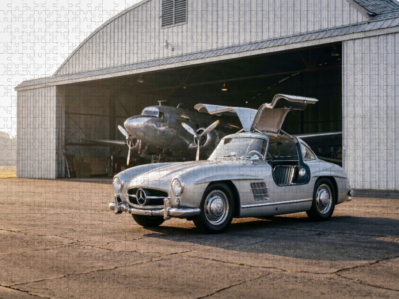 Mercedes-Benz 300 SL „Flügeltürer“ (Deutschland, 1954-57) vor einem Flugzeughangar im Morgenlicht