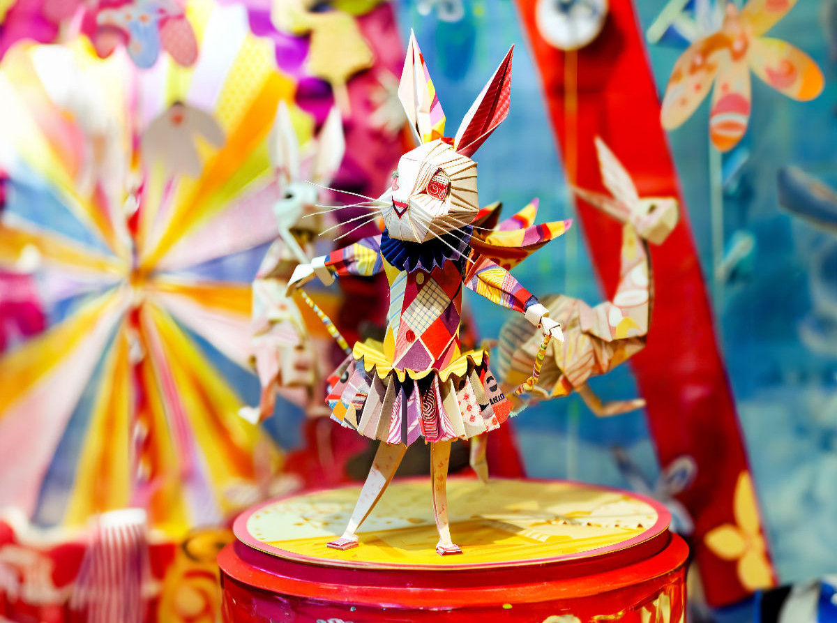 Origamihase im Zirkus trägt historisches Kostüm in bunter Papierwelt